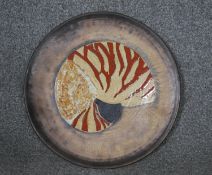 A ceramic charger with central nautilus decoration, signed R Mack. D.45
