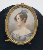 A 19th century brass framed and glazed miniature on ivory of a lady in a blue dress with bow in