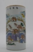 A Famille Rose style cylindrical vase/brush pot with landscape decoration and Chinese characters.