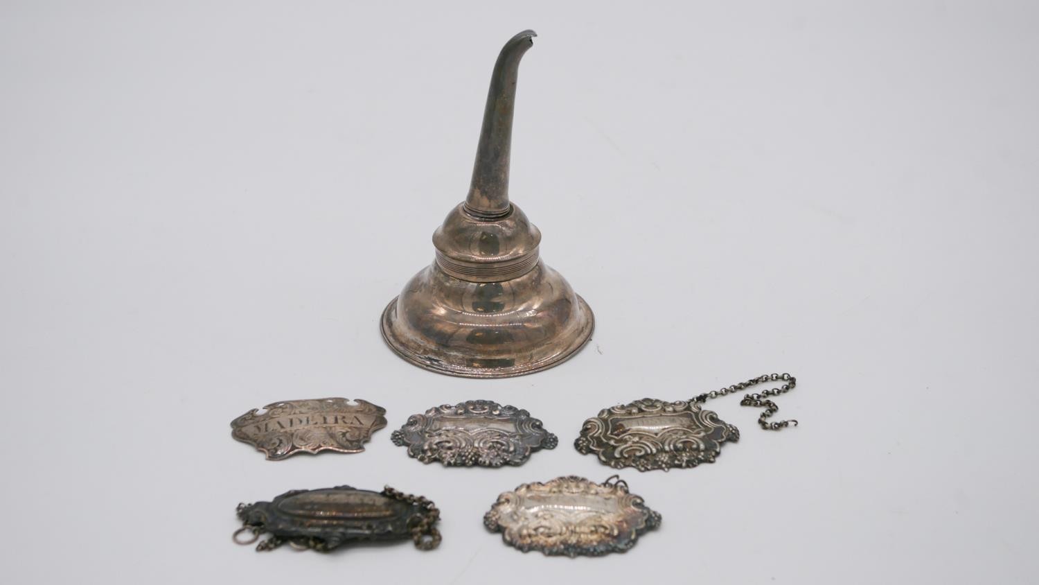 A Georgian silver wine funnel along with five silver drinks labels. Weight 109g