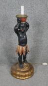 A carved painted and gilded wooden blackamoor table lamp. H.60cm