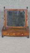 A 19th century mahogany dressing table mirror with swing plate above a pair of base drawers on bun