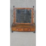 A 19th century mahogany dressing table mirror with swing plate above a pair of base drawers on bun