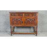 A mid century Jacobean style carved oak sideboard on stretchered barleytwist supports. H.90 W.104