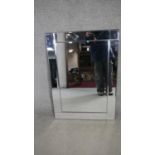 A contemporary wall mirror in glazed frame. H.93 W.67cm