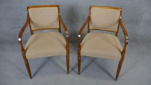 A pair of contemporary late Georgian style armchairs on reeded tapering supports.