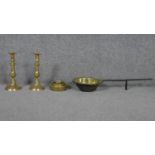 A pair of brass candlesticks, a set of weights and an antique brass and iron skillet.