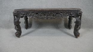 A carved Burmese hardwood coffee table on cabriole supports. H.44 W.90 D.46cm