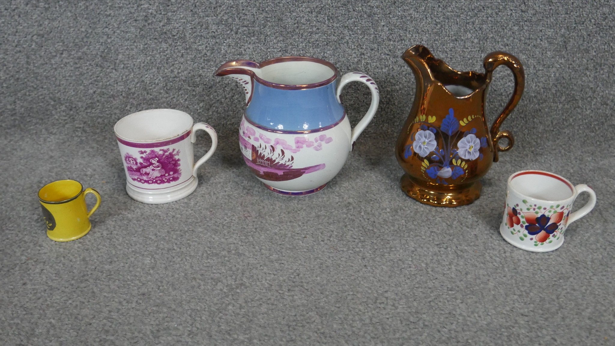 A collection of 19th century lustreware jugs and cups. Including a Sunderland ware jug painted