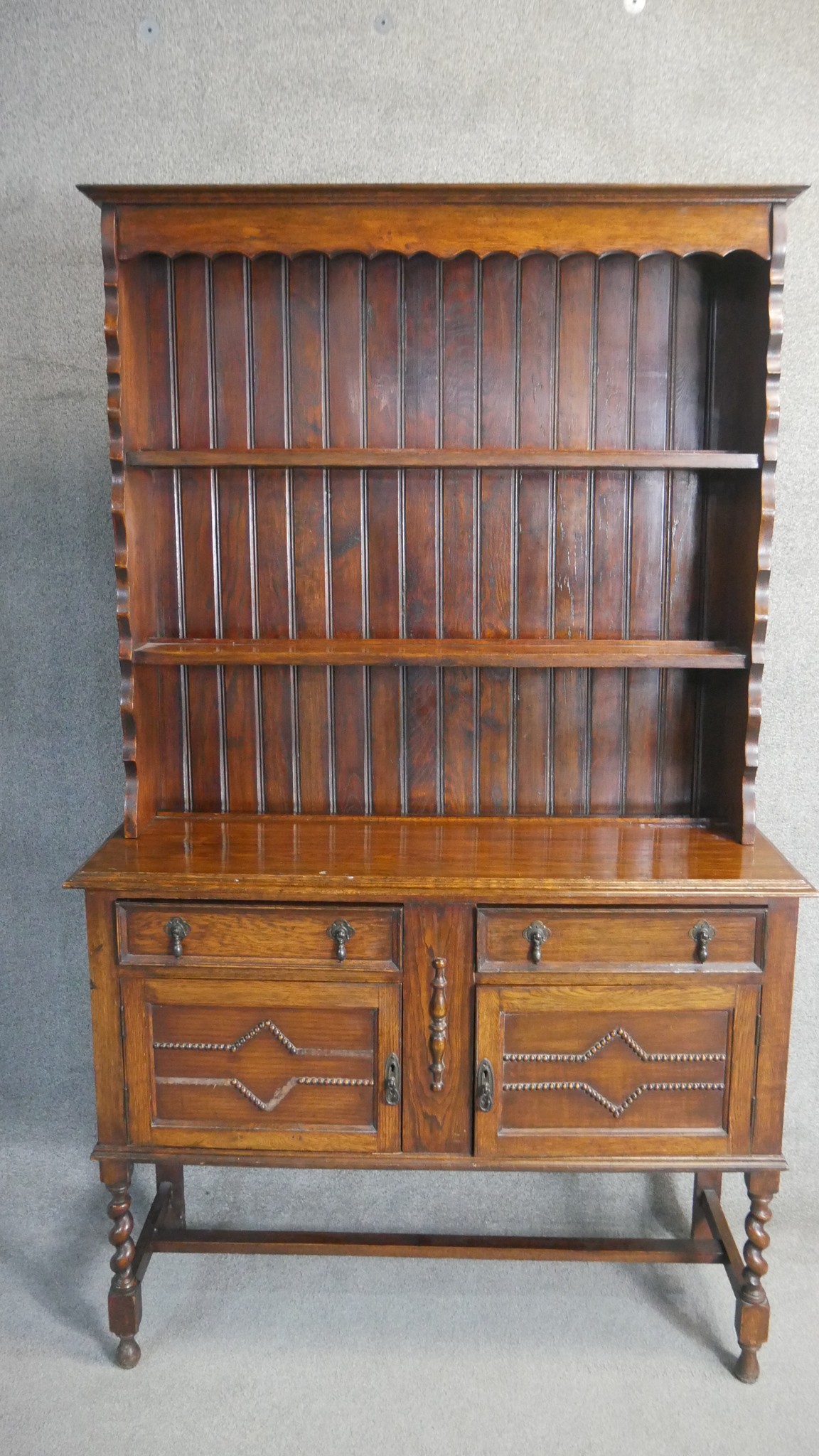 A George V oak dresser and rack, Jacobean style, the rack with three shelves, the base section