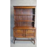 A George V oak dresser and rack, Jacobean style, the rack with three shelves, the base section