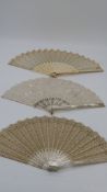 Three boxed 19th century fans. One gilded carved and pierced mother of pearl fan, the silk