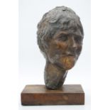 A sculpted bronze head of a female figure. Mounted on a wooden base. H.42cm
