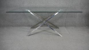 A contemporary dining table with plate glass top on chrome X framed supports. H.73 W.180 D.100cm