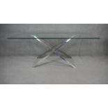 A contemporary dining table with plate glass top on chrome X framed supports. H.73 W.180 D.100cm