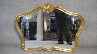 A shaped gilt framed wall mirror with shell cresting. H.78 W.100cm