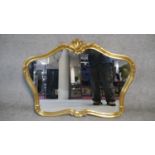 A shaped gilt framed wall mirror with shell cresting. H.78 W.100cm