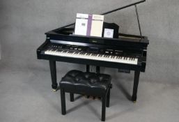 A Roland KR 115 digital intelligent grand piano finished in black lacquered case along with matching