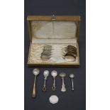 A cased set of white metal (tested silver) floral engraved coffee spoons, marked AE along with white