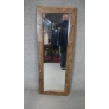 An Eastern teak metal studded mirror. H.122cm