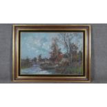 A large framed oil on canvas, cottage by a river, signed L Baguet. W.110 H.82