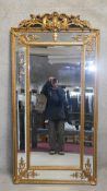 A large moulded gilt framed pier mirror with shell cresting and scrolling foliate decoration. H.