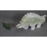 A large carved Chinese jade bull sculpture with engraved floral motifs along with a carved green