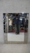 A contemporary wall mirror in glazed frame. H.103 W.76cm