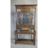 A Jacobean style oak hall stand, 20th Century, with mirrored back, glove box to centre and