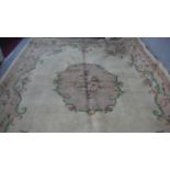 A handmade Indian carpet with central floral spray medallion on a cream ground. 364x273cm