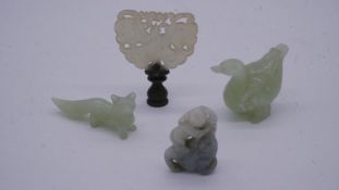 A miscellaneous collection of Chinese carvings in jade and coral, including figures, animals, and