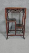 A C.1900 Chinese hardwood occasional table with pierced carved frieze and assymetric undertiers on