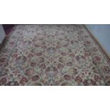 A woollen carpet with all over scrolling lotus flower decoration on a fawn ground. 360x270cm