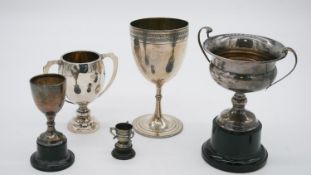 A collection of five silver trophy cups. Three on wooden and plastic bases. Various British