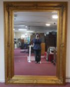 A very large mirror with bevelled plate in foliate decorated gilt frame. H.235 W.175cm