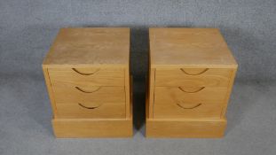 A pair of contemporary light oak bedside chests with three drawers on plinth bases. H.60 W.50 W.50cm