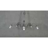 A wrought metal five branch chandelier with scrolling arms. Dia.90cm