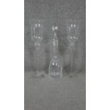 A pair of etched glass storm lanterns and a cut crystal decanter with stopper.