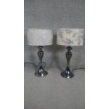 A pair of contemporary table lamps on metal baluster bases.