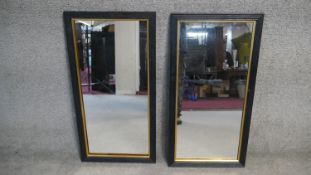 A pair of ebonised reeded framed wall mirrors with gilt slips. H.80 W.40cm