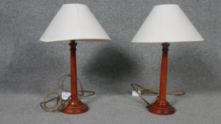 A pair of mahogany table lamps with shades.