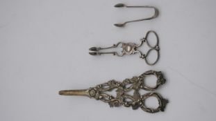 A collection of silver tongs. Including a pair of Georgian sculpted vine design grape scrissors by