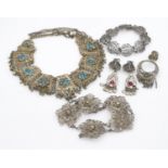 A collection of white metal filligree wire jewellery. Including an articulated filigree work