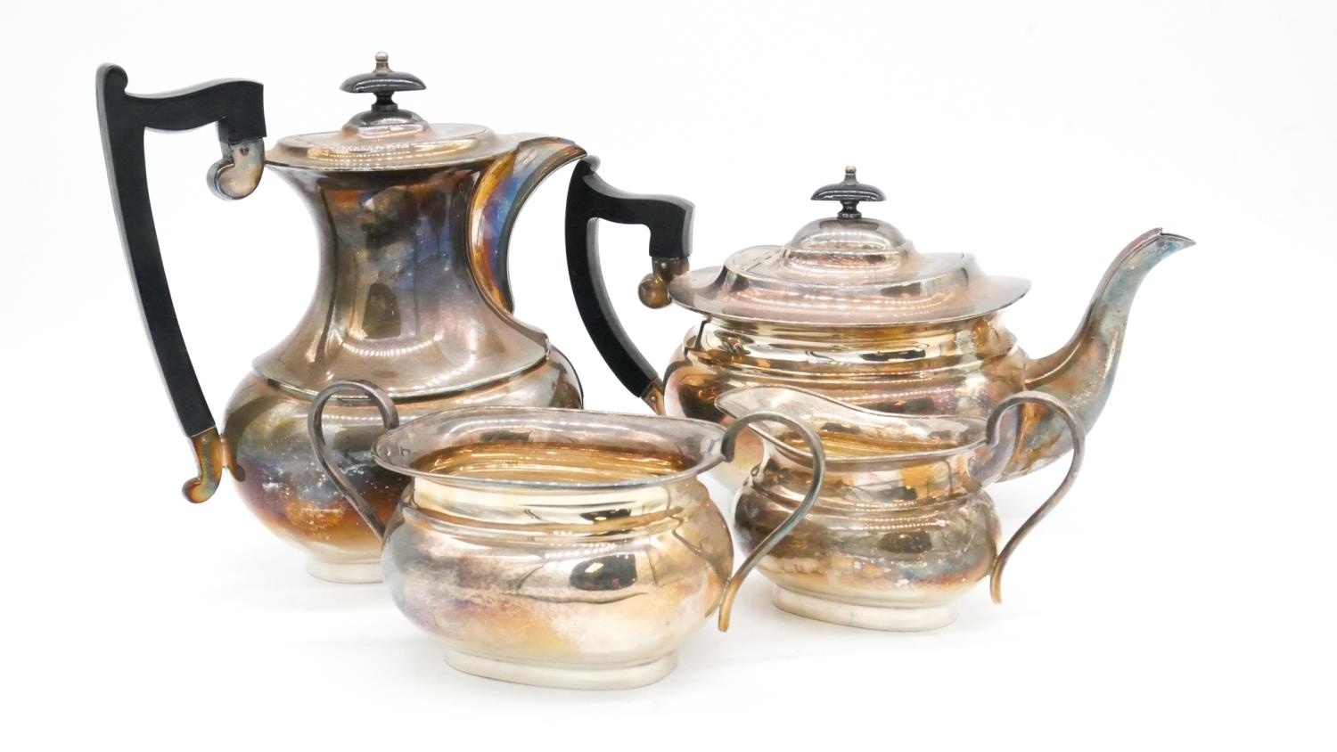 A four piece silver plated coffee and tea service, the tea pot and coffee pot having ebony