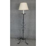 A mid century wrought iron lamp standard on tripod scrolling supports. H.165cm