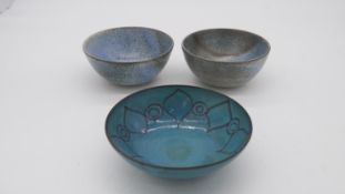Three Studio Pottery blue glazed terracotta bowls. One with abstract floral design. Makers marks