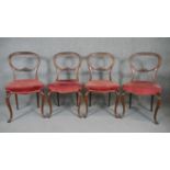 A set of four mahogany balloon back dining chairs on carved cabriole supports.