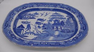 A large 19th century blue and white willow pattern ceramic meat platter. Impressed numbers to the