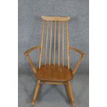 A vintage Ercol child's Windsor rocking chair with beech frame and burr elm seat.