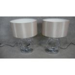 A pair of contemporary table lamps with hooped chrome bases.